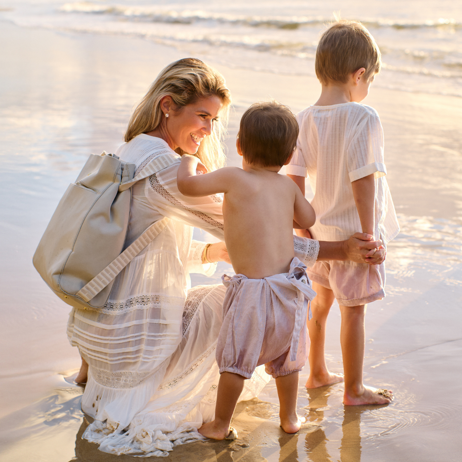 Mother Laura King with her children holding H Bag as a backpack at the beach