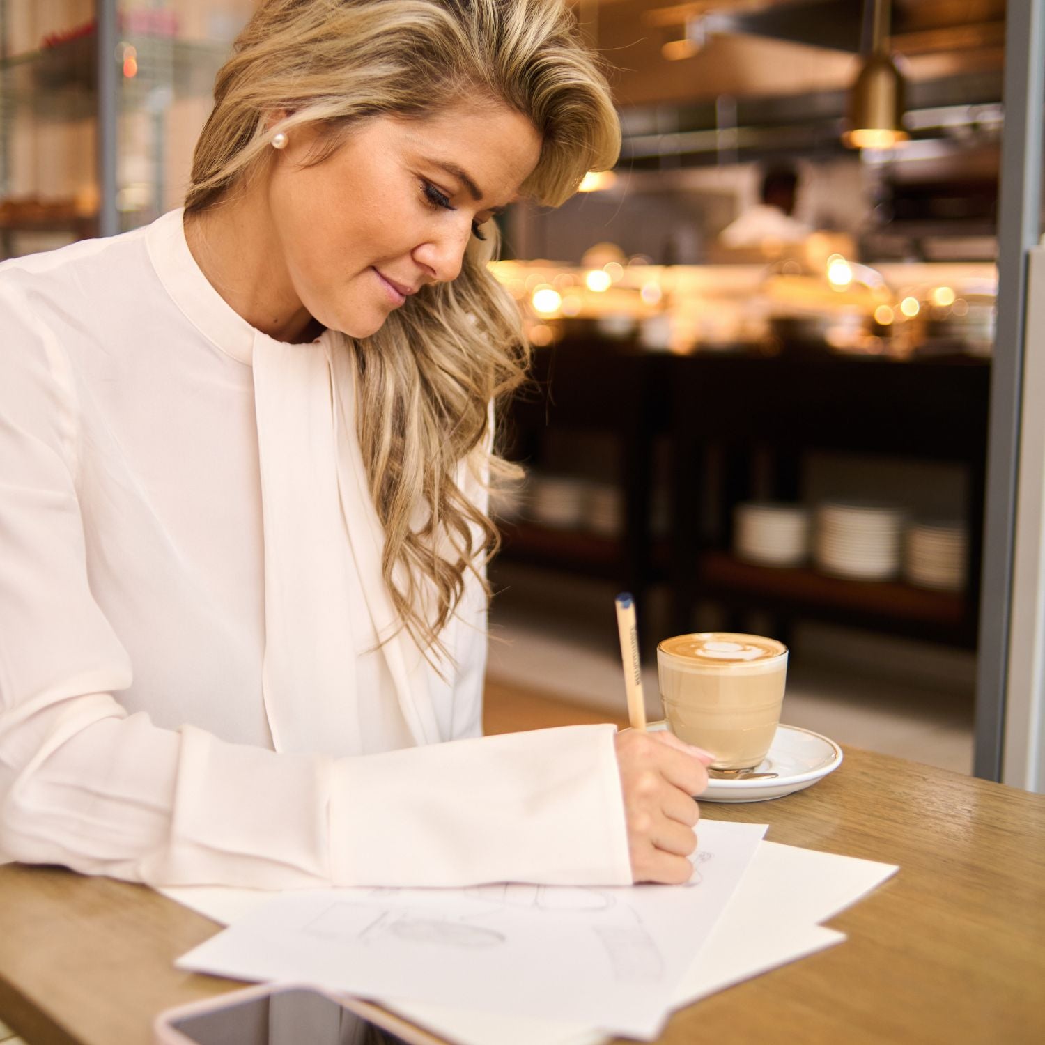 Designer Laura King drawing handbag designs with pencil